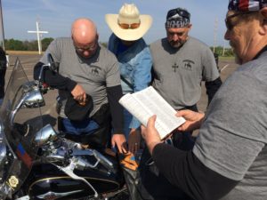 Bikers pray for each other before kickstands go up for a benefit ride to benefit HorsePowerKids.